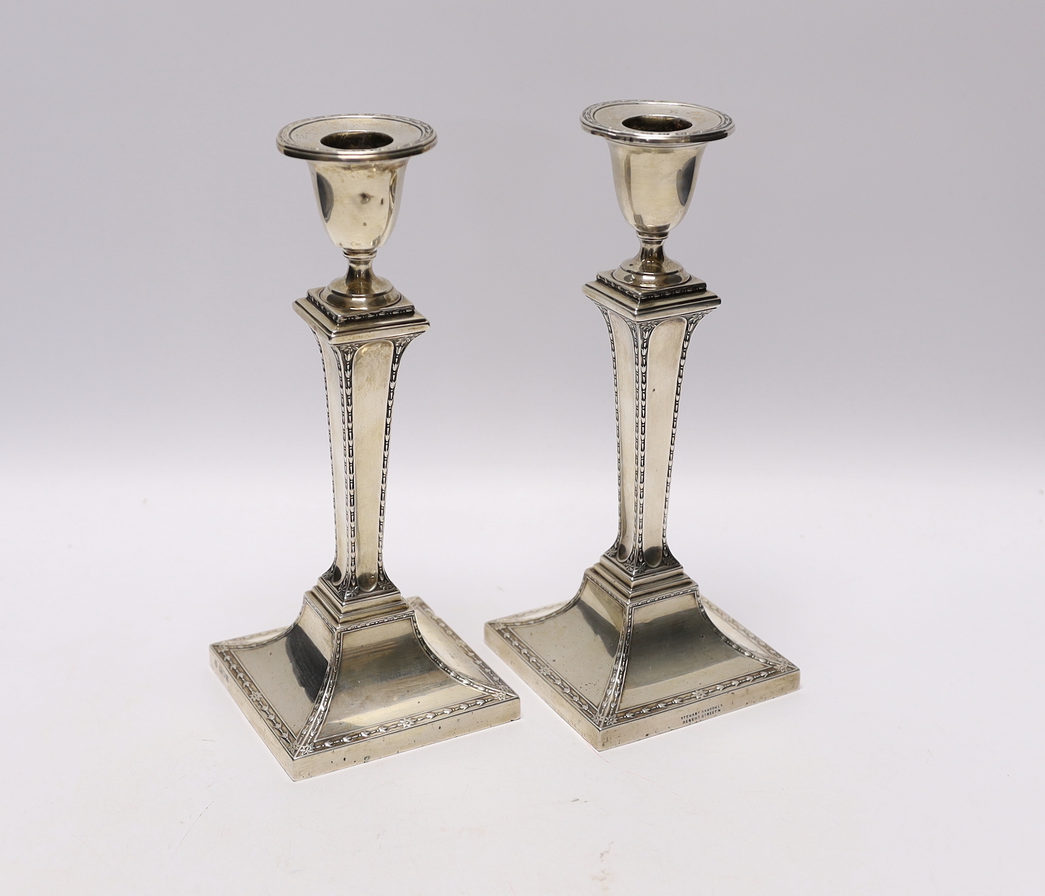 A pair of Edwardian silver candlesticks, with tapering square stems, Stewart Dawson & Co Ltd, London, 1909, height 22.3cm, weighted.